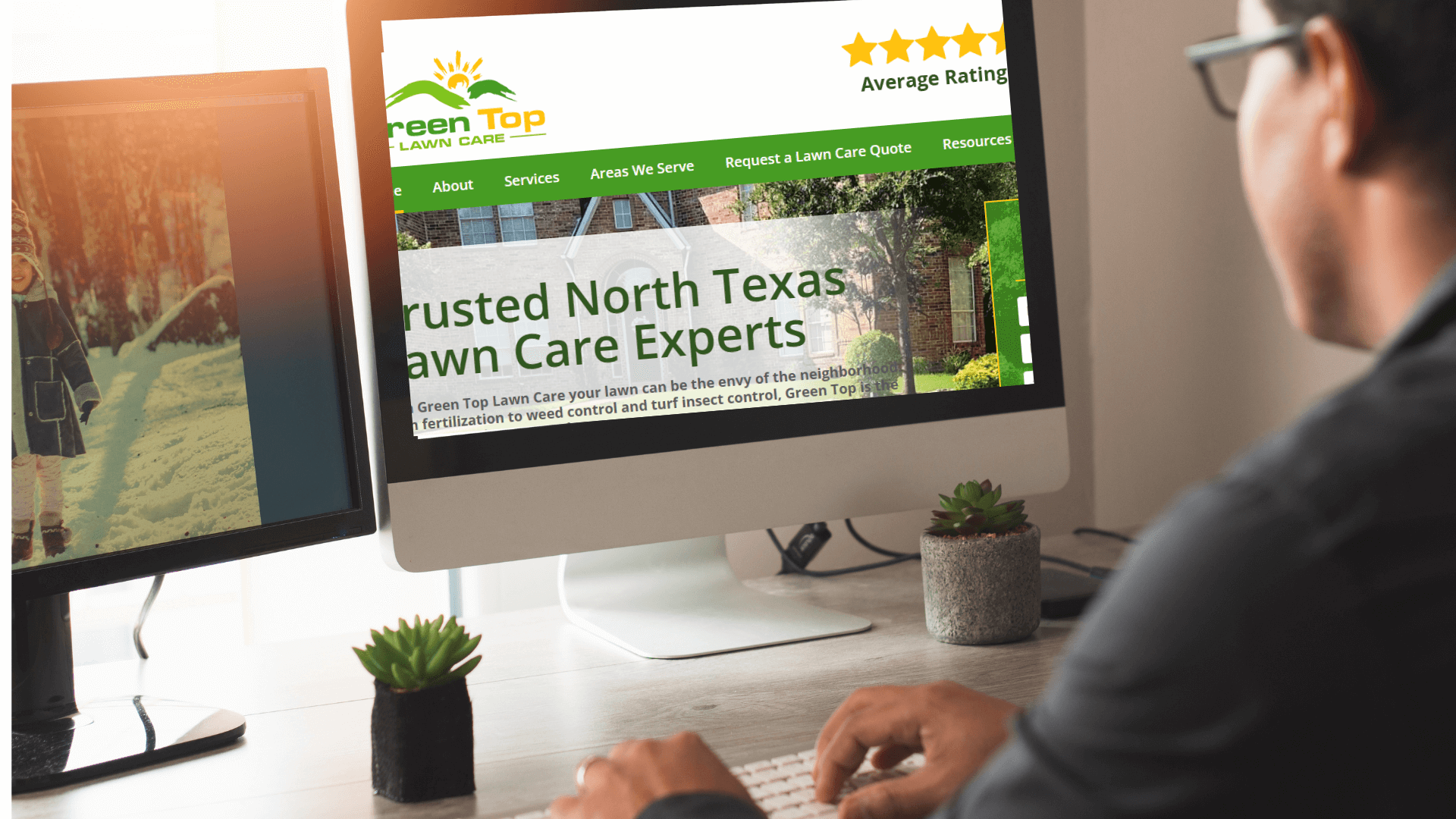 A person at a desk uses a computer to view the landing page for "Green Top Lawn Care," known for persuasive details of their lawn care services in North Texas. The website depicts an average star rating. Nearby, a second monitor showcases a serene winter scene photo.